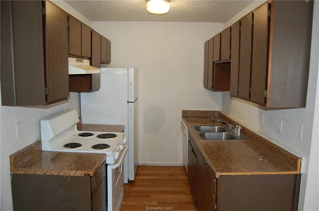 1535 Pine Ridge Drive, Unit C College Station, TX 77840 - Photo 4 of 14 a kitchen with stainless steel appliances granite countertop a stove a sink and a refrigerator
