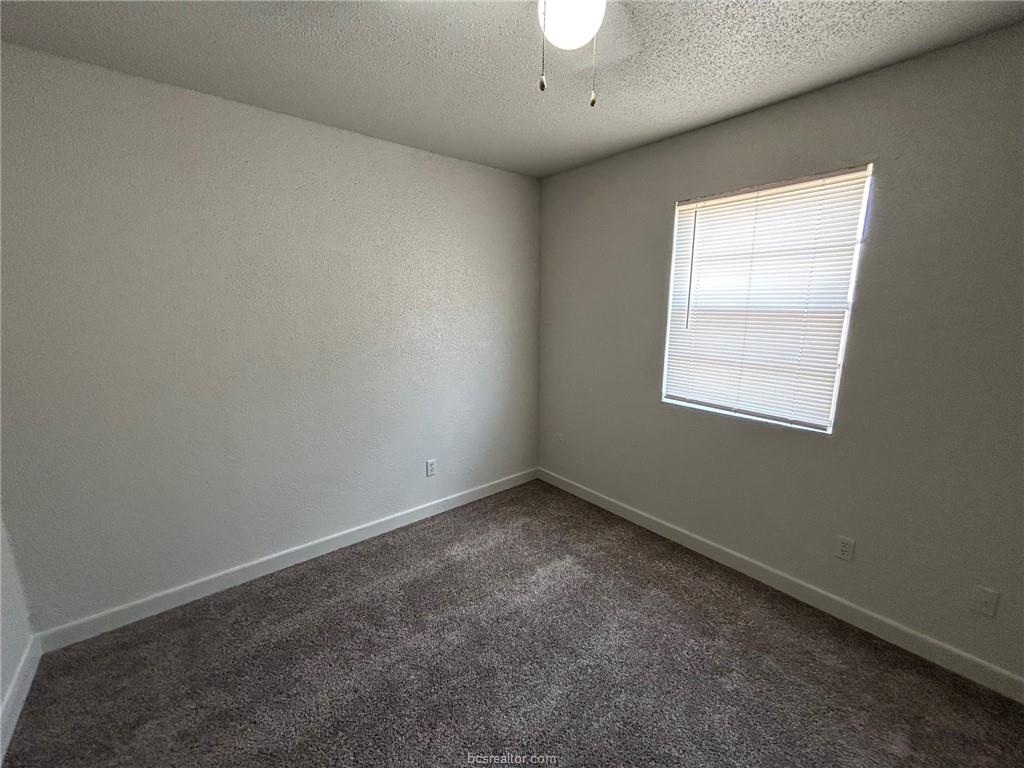 1535 Pine Ridge Drive, Unit C College Station, TX 77840 - Photo 10 of 14 Unfurnished room with dark carpet and a textured ceiling