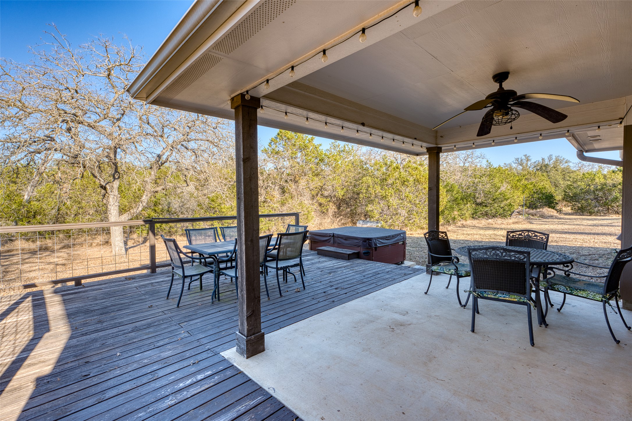 489 Nordic Ridge Road Bertram, TX 78605 - Photo 11 of 19 View of patio featuring outdoor dining area, ceiling fan, a hot tub, and a wooden deck