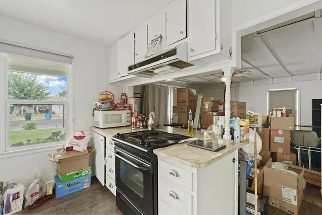 a kitchen that has a stove and a white wooden cabinets