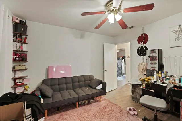 a living room with furniture a rug and a ceiling fan