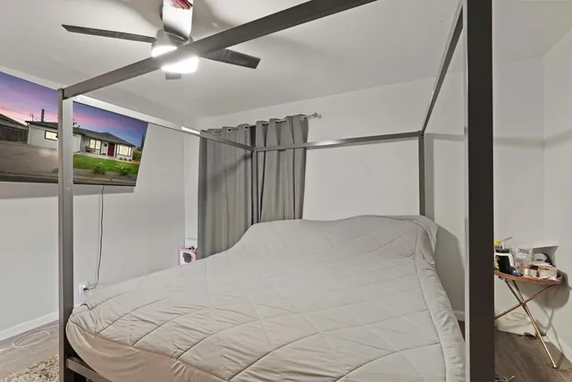 a bedroom with a bed and a ceiling fan
