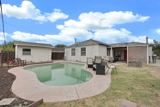 a view of a house with swimming pool and sitting area