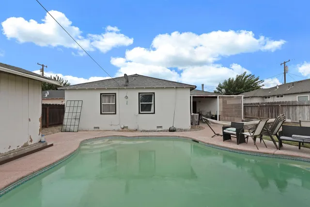 a backyard of a house with table and chairs