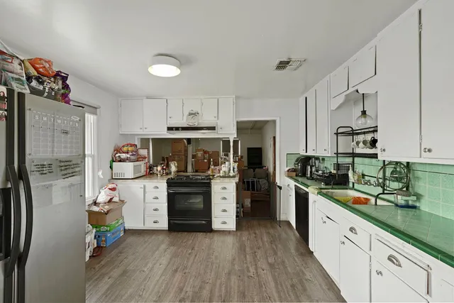 a kitchen with stainless steel appliances a stove a sink cabinets and a refrigerator