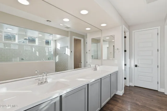 a bathroom with a double vanity sink mirror and shower