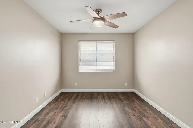 an empty room with a window and a fan