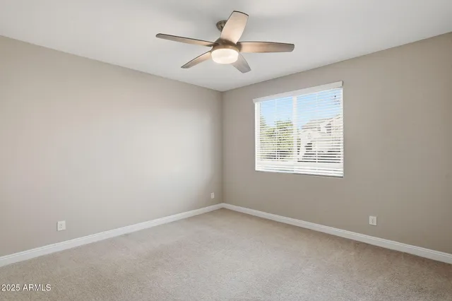 an empty room with a window and a ceiling fan