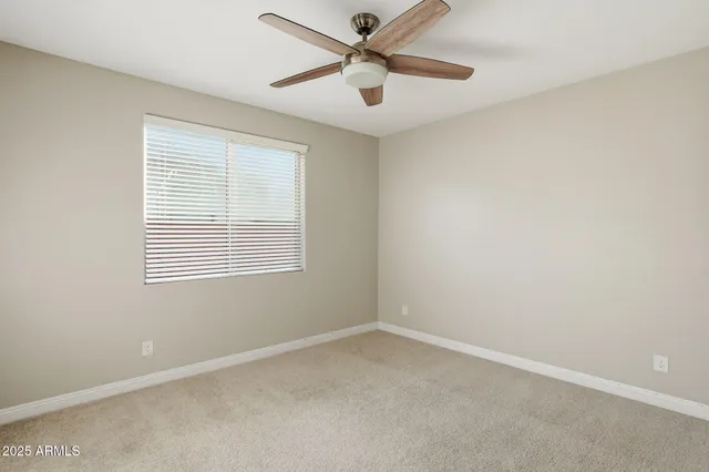 an empty room with a window and a fan