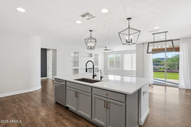 a kitchen with kitchen island granite countertop a sink a counter space and stainless steel appliances