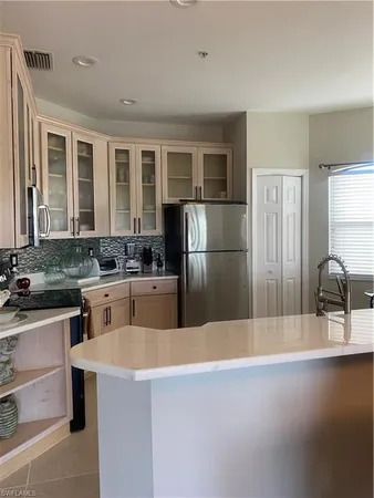a kitchen with a refrigerator a sink a stove and cabinets