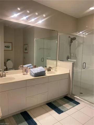 a bathroom with a double vanity sink mirror and shower