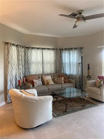 a living room with couches and a potted plant on a coffee table