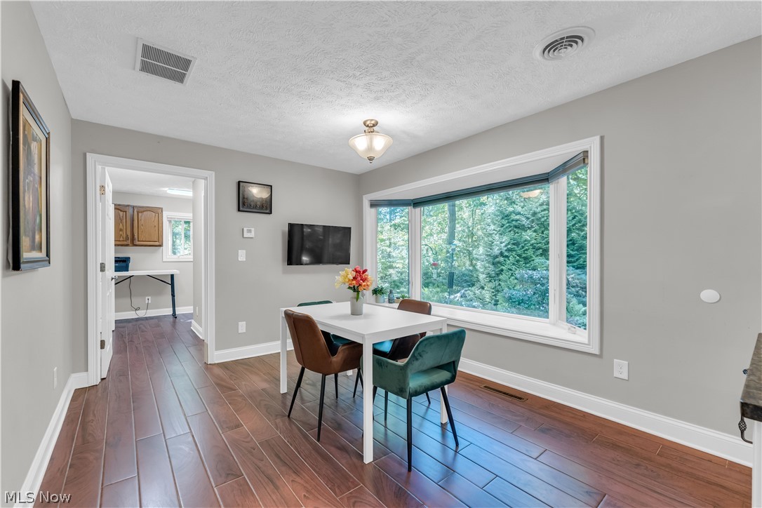 6821 Thornapple Road Gates Mills, OH 44040 - Photo 12 of 42 Spacious interior with wood-finish flooring, a large bay window, light gray wall paint, white trim, and a built-in overhead light fixture