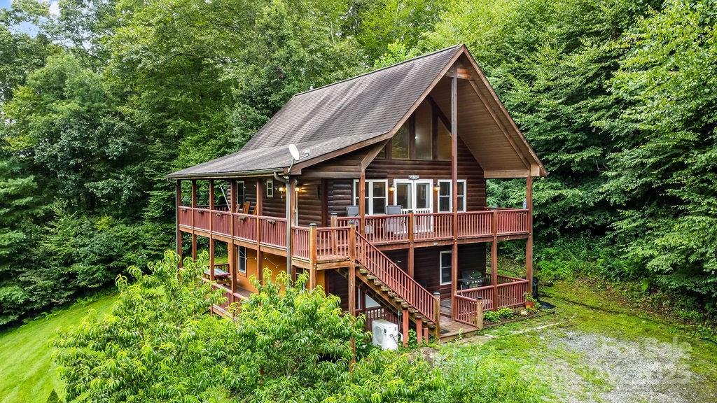 an aerial view of a house with balcony and trees al around