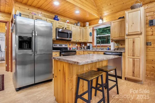 a kitchen with granite countertop a refrigerator and microwave