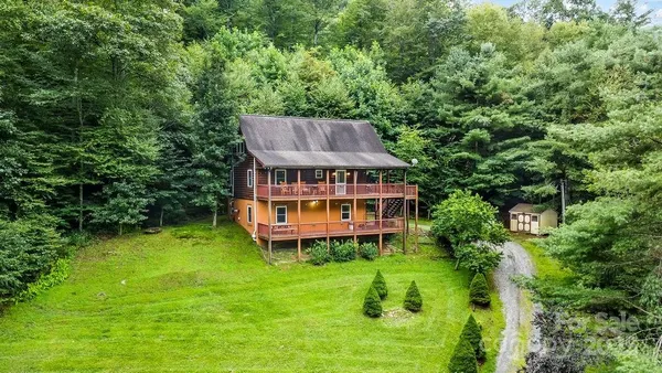 an aerial view of a house with swimming pool next to a big yard