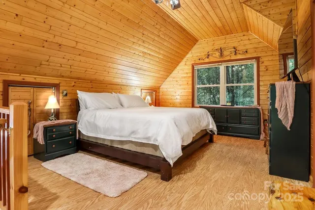 a bedroom with a bed a dresser next to a window