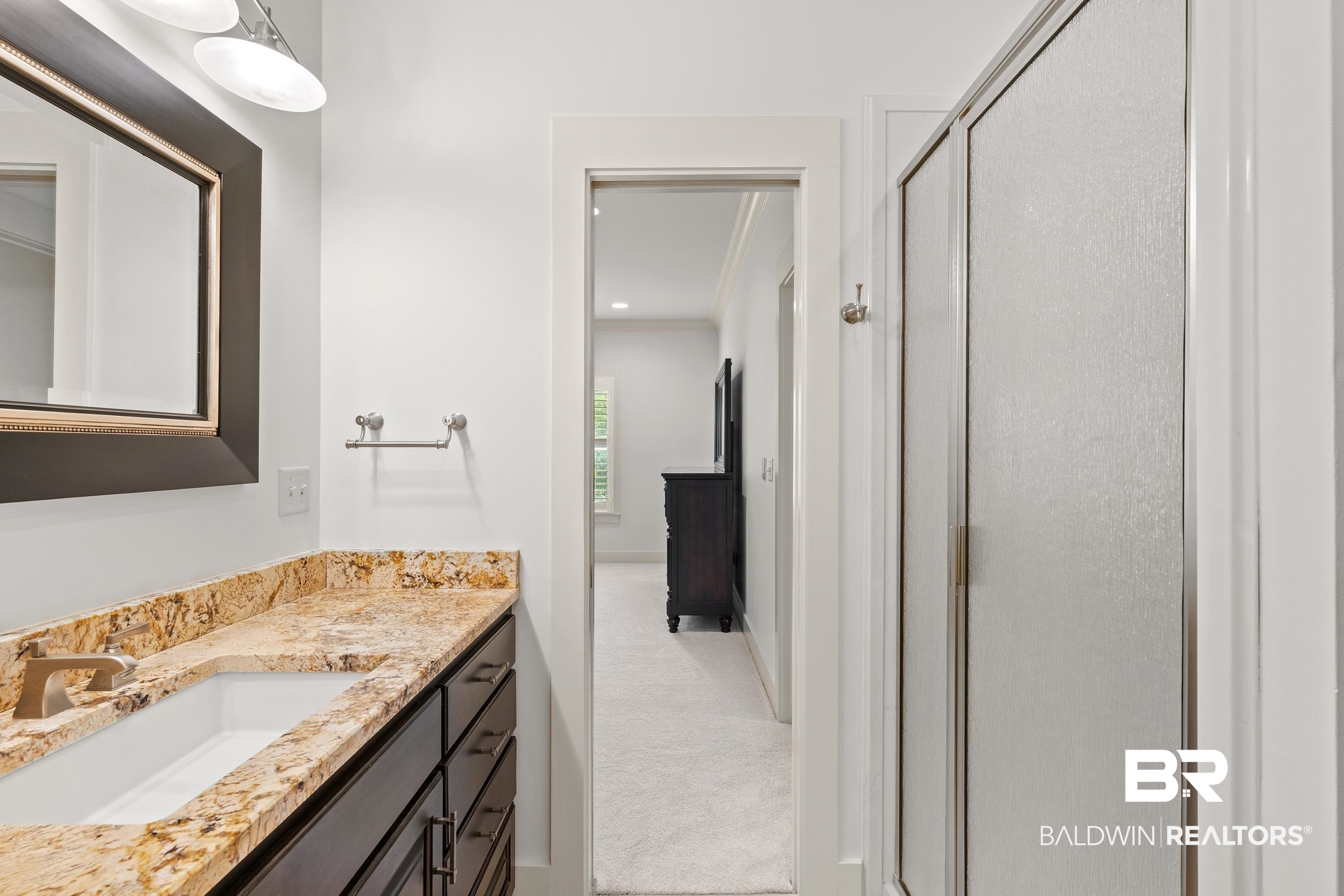 30463 Dolive Ridge Daphne, AL 36527 - Photo 57 of 58 Vanity featuring a stone countertop, undermount sink, and dark wood cabinetry