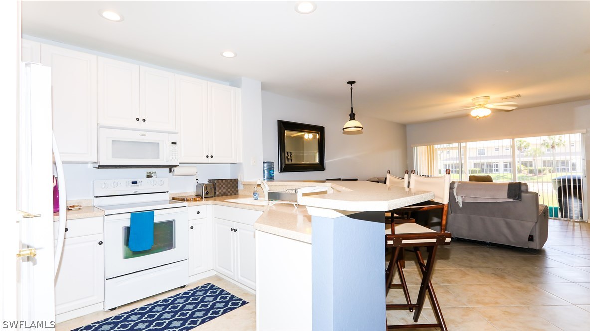 11709 Eros Road Lehigh Acres, FL 33971 - Photo 3 of 25 a kitchen that has a cabinets and a stove