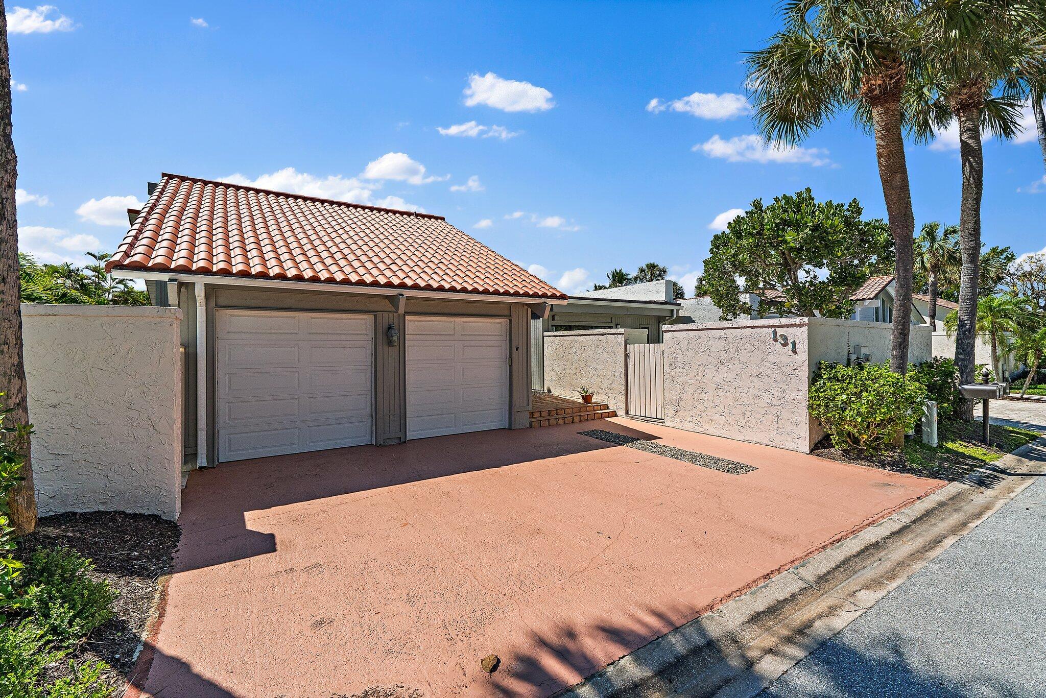 131 Bonefish Circle Jupiter, FL 33477 - Photo 2 of 48 a front view of a house with a garage
