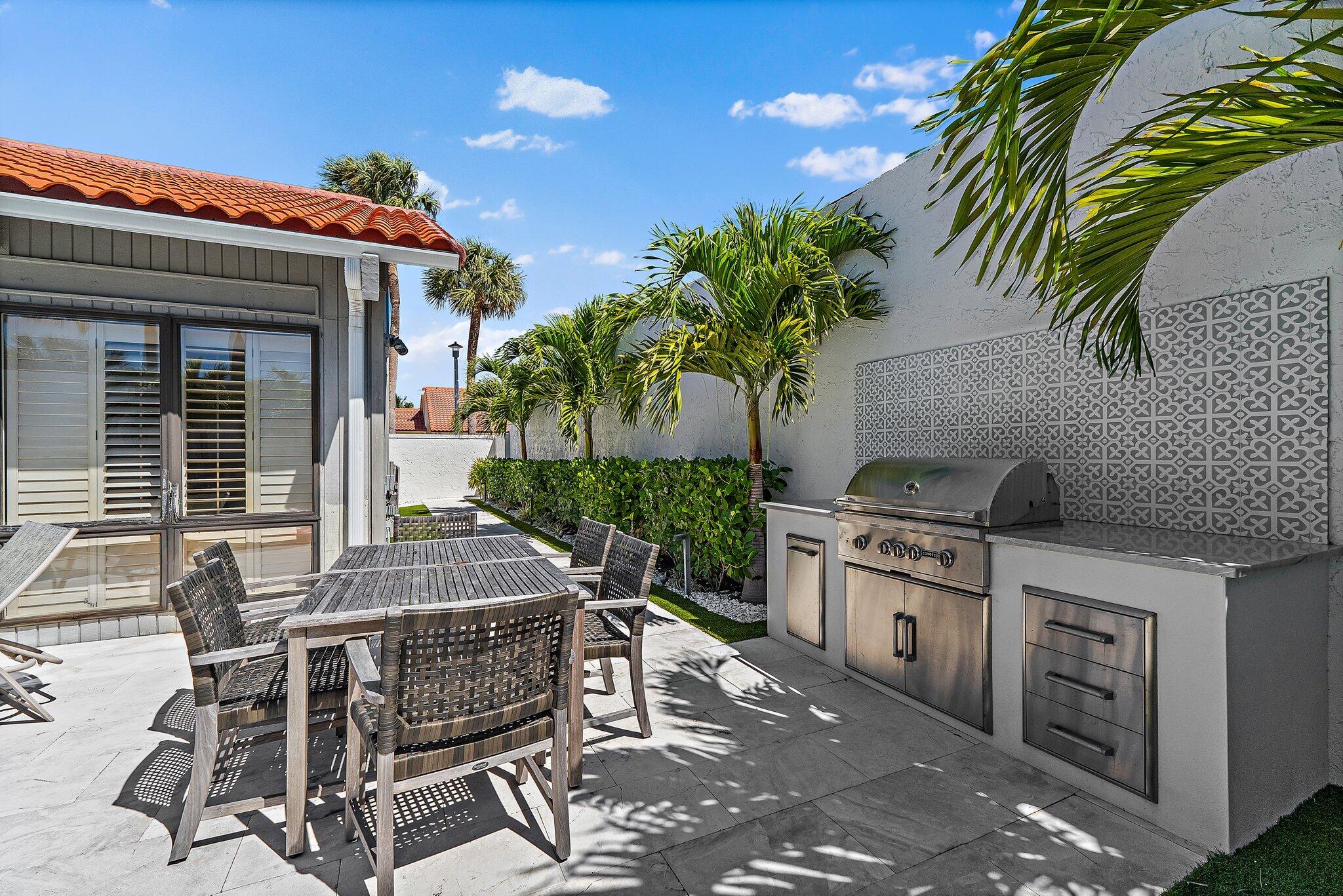 131 Bonefish Circle Jupiter, FL 33477 - Photo 41 of 48 a patio with a table and chairs and potted plants