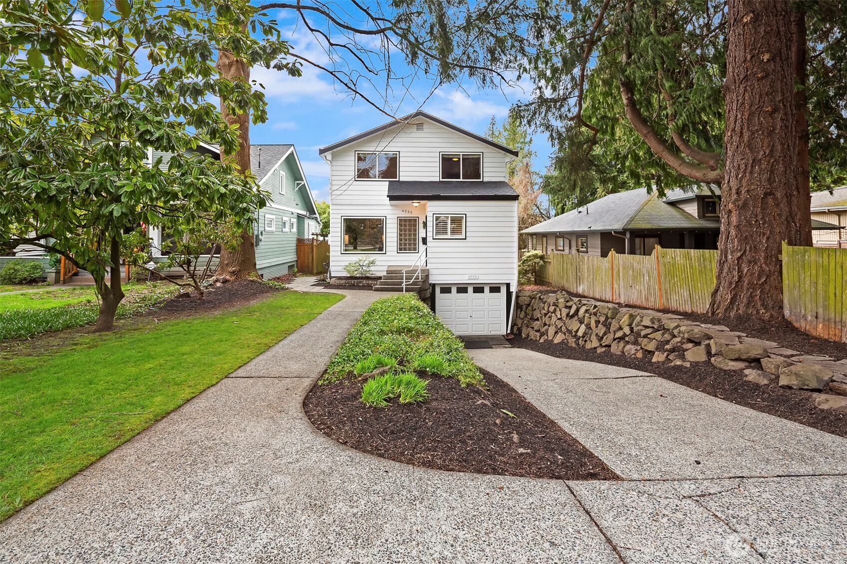 6939 Fauntleroy Way Southwest Seattle, WA 98136 - Photo 2 of 35 a front view of a house with a yard and trees