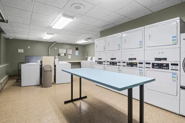 a kitchen with a table chairs refrigerator and cabinets