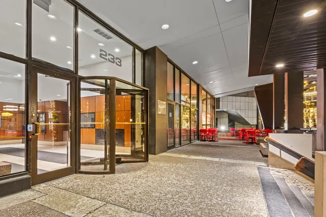 a living room with entrance to ceiling window and glass door