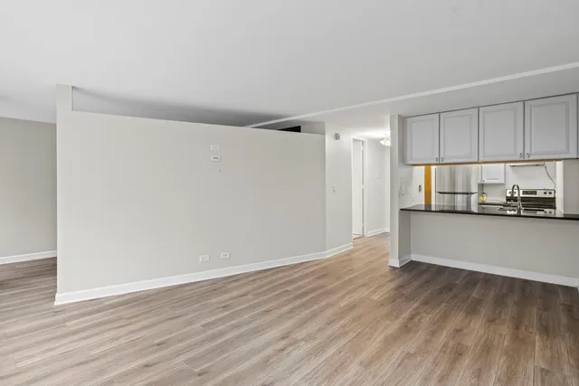 a view of a kitchen with wooden floor and electronic appliances
