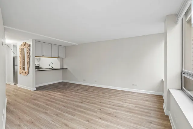 a view of kitchen refrigerator and wooden floor