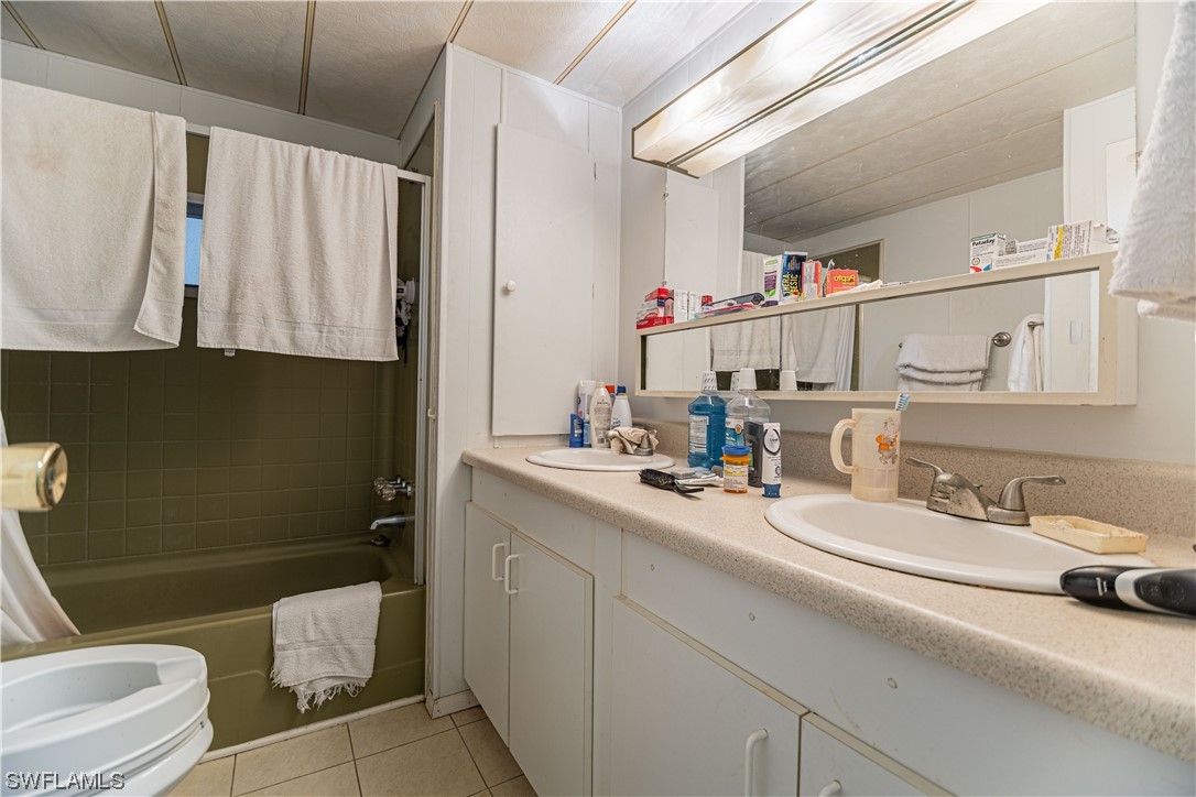 8 Henderson Drive Naples, FL 34114 - Photo 13 of 16 a bathroom with a sink a toilet and a mirror