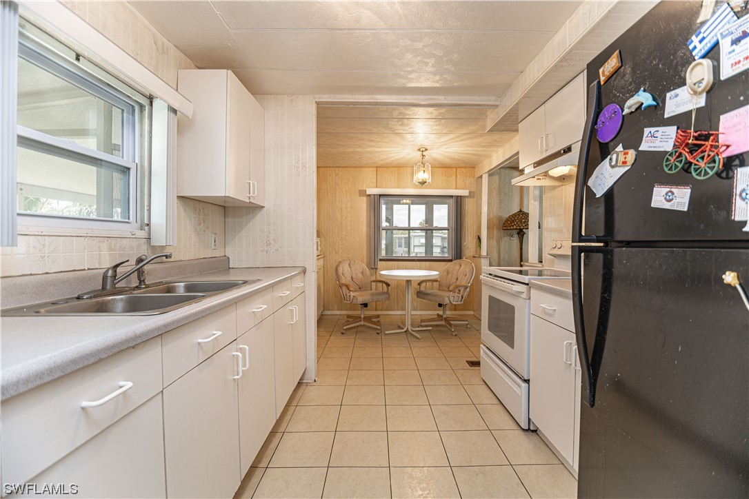 8 Henderson Drive Naples, FL 34114 - Photo 7 of 16 a kitchen with granite countertop a sink stove and cabinets