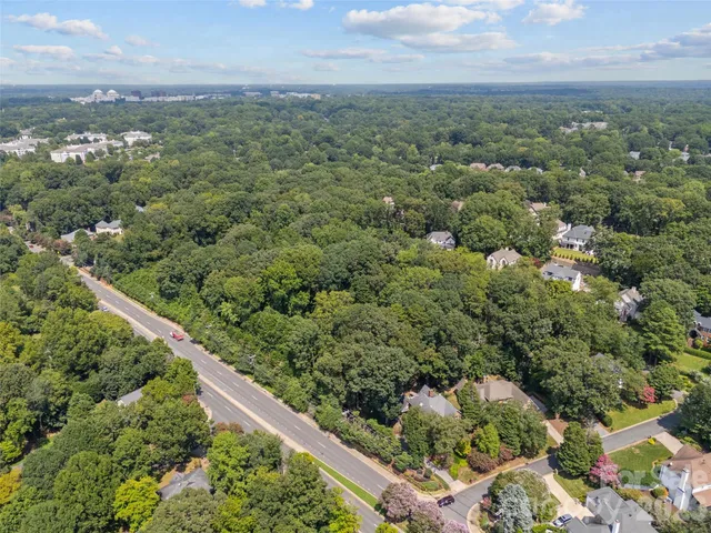 an aerial view of a house with a yard and mountain view in back