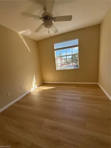 en empty room with windows and ceiling fan
