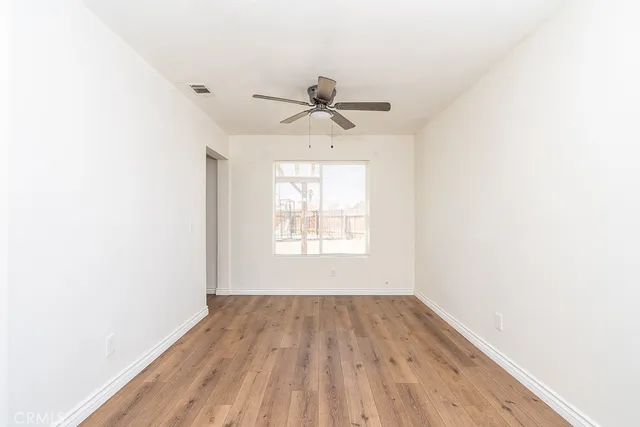 a view of a room with a window and wooden floor