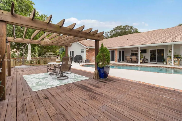 a view of a patio with table and chairs with wooden floor and fence