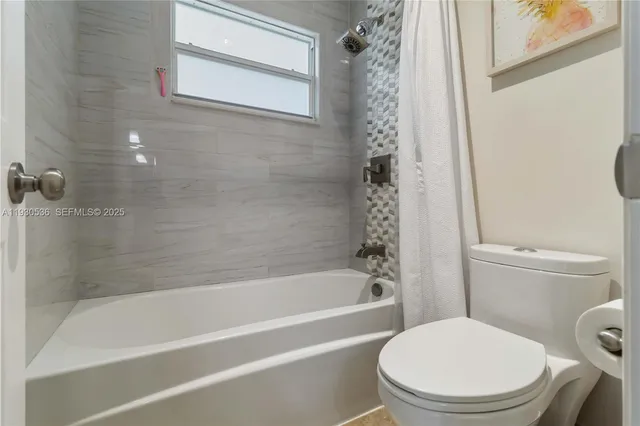 a white toilet and tub sitting next to a bathroom sink