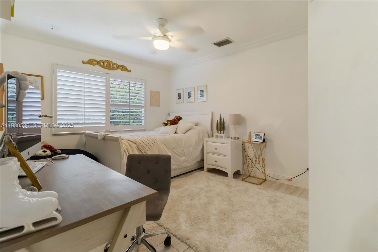 2047 Southwest 36th Avenue Delray Beach, FL 33445 - Photo 31 of 45 a bedroom with a bed and a chandelier