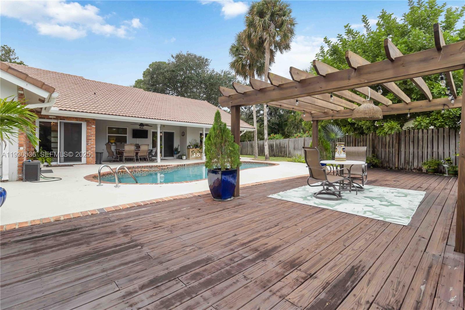 2047 Southwest 36th Avenue Delray Beach, FL 33445 - Photo 33 of 45 a view of a patio with table and chairs potted plants and wooden floor