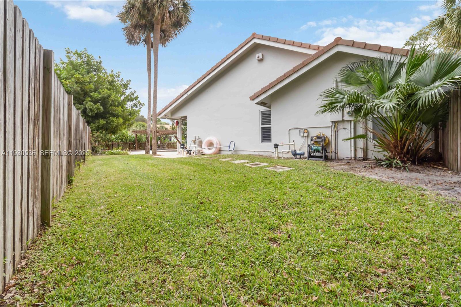 2047 Southwest 36th Avenue Delray Beach, FL 33445 - Photo 35 of 45 a view of a house with a yard and potted plants