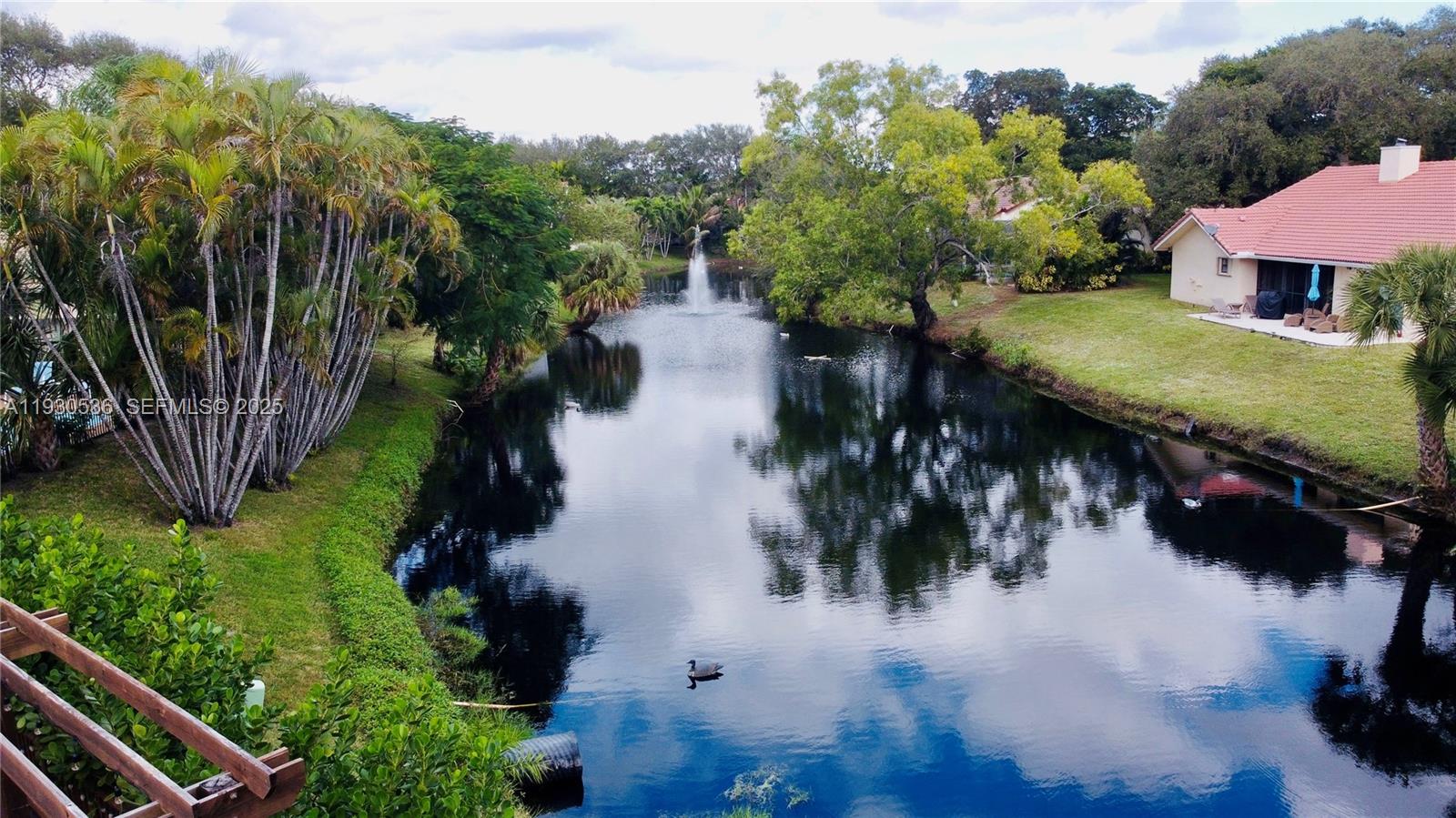 2047 Southwest 36th Avenue Delray Beach, FL 33445 - Photo 44 of 45 a view of a lake with a house in the background