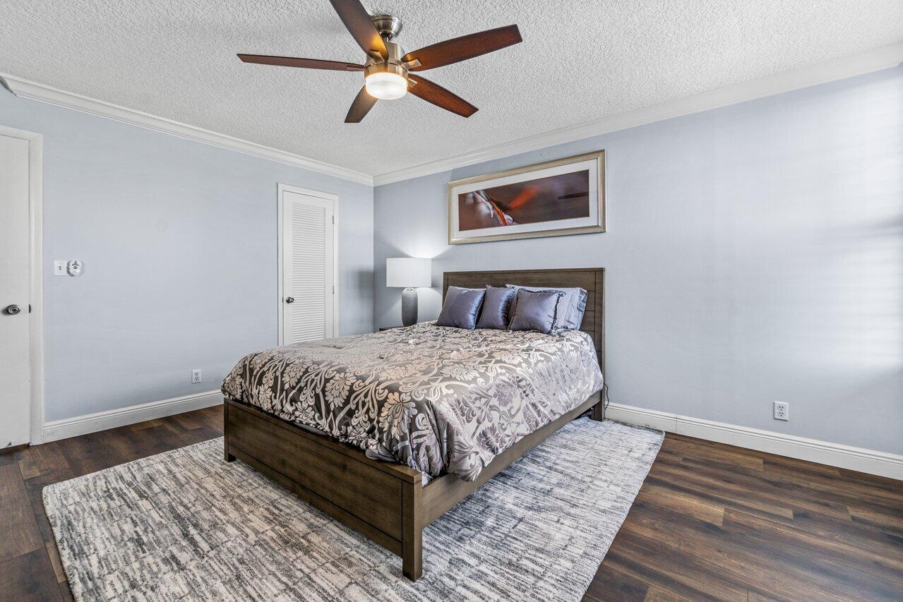 14 Royal Palm Way, Unit 504 Boca Raton, FL 33432 - Photo 14 of 22 a bedroom with a large bed and a chandelier