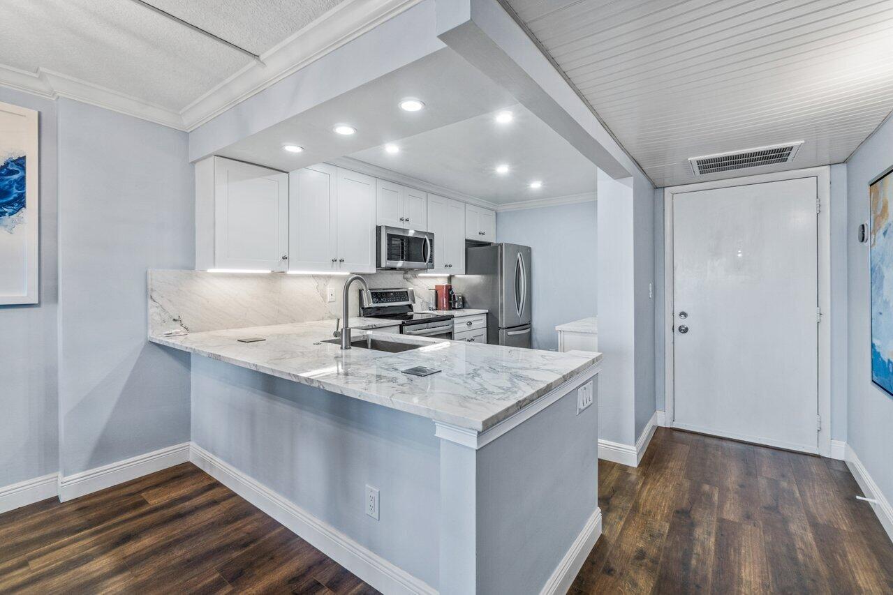 14 Royal Palm Way, Unit 504 Boca Raton, FL 33432 - Photo 2 of 22 a kitchen with kitchen island a sink appliances and cabinets