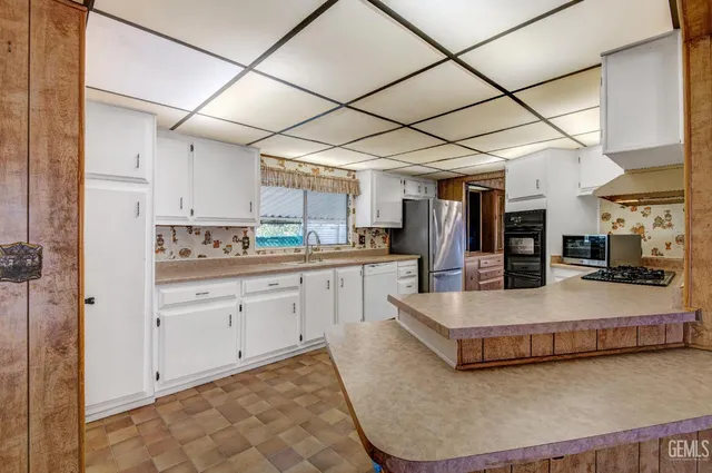 a large white kitchen with a large window