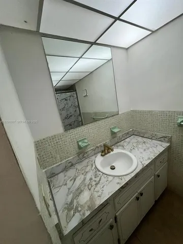 a bathroom with a granite countertop toilet and a shower