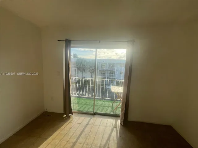 a view of a room with wooden floor and a window