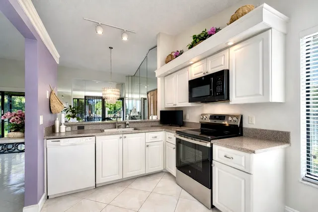 a kitchen with white cabinets stainless steel appliances and sink