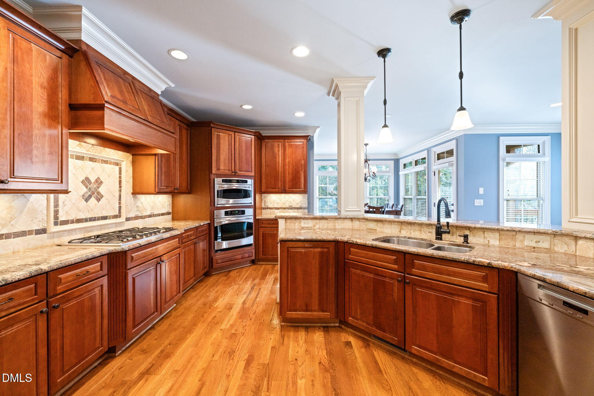 12313 The Gates Drive Raleigh, NC 27614 - Photo 18 of 78 a open kitchen with stainless steel appliances granite countertop wooden floors wooden cabinets a sink and a center island