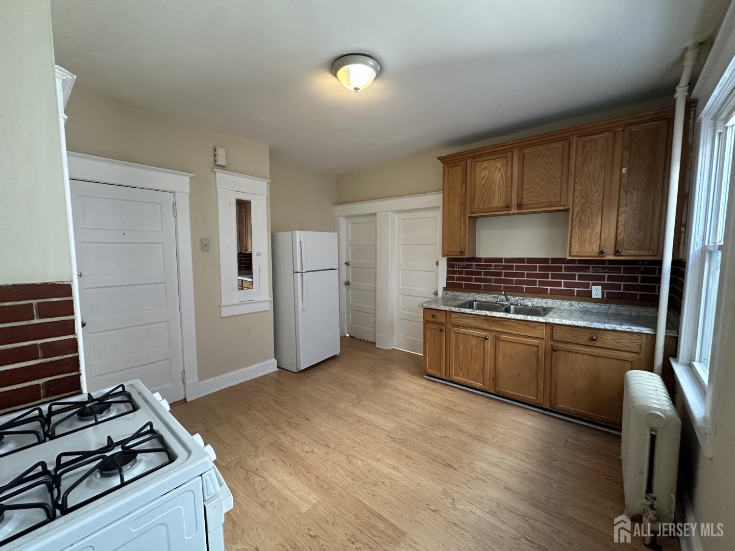 66 Louis Street New Brunswick, NJ 08901 - Photo 6 of 10 a kitchen with granite countertop a stove and a refrigerator